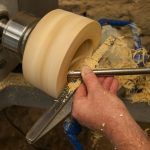 a man is working on a piece of wood